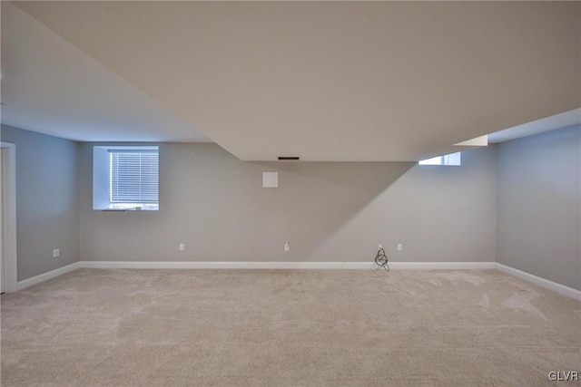 basement featuring light colored carpet