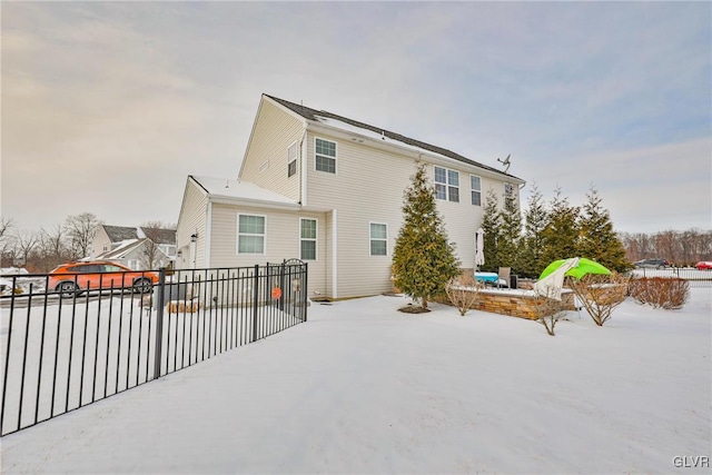 view of snow covered back of property