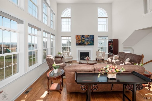 living room with hardwood / wood-style floors and a towering ceiling