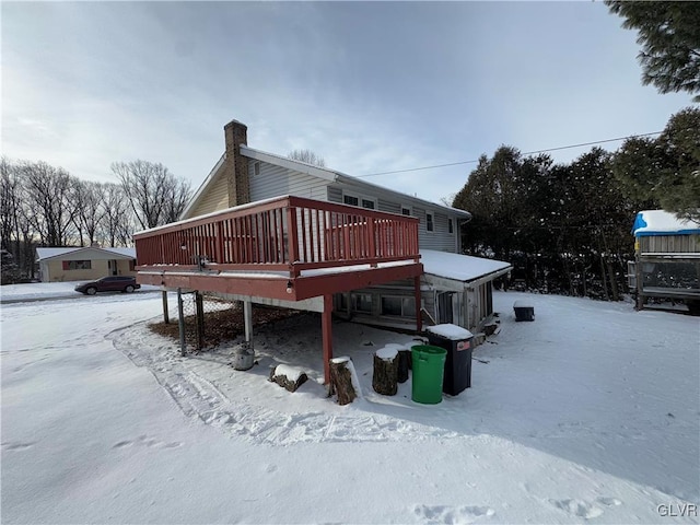 snow covered property with a deck