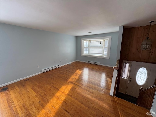 entrance foyer featuring a baseboard heating unit and wood-type flooring