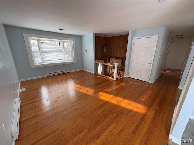 unfurnished living room with hardwood / wood-style flooring and a baseboard radiator