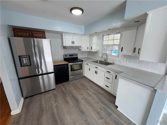 kitchen featuring hardwood / wood-style flooring, white cabinetry, sink, backsplash, and stainless steel appliances