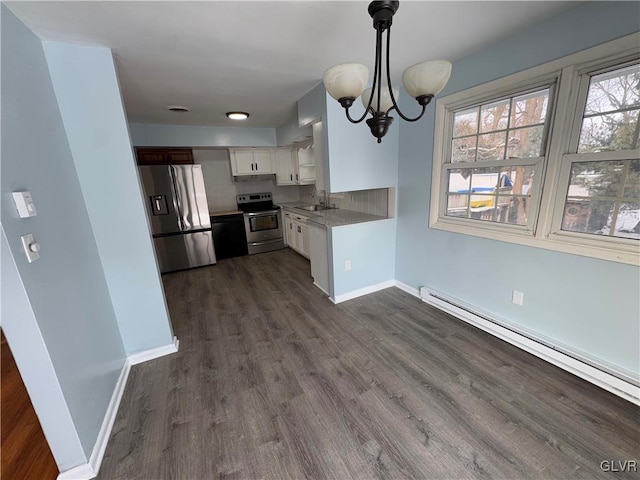 kitchen featuring a baseboard heating unit, white cabinets, sink, pendant lighting, and stainless steel appliances