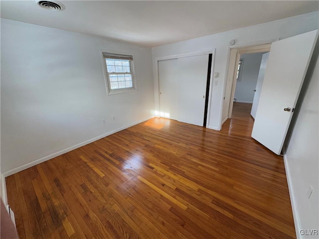 unfurnished bedroom with hardwood / wood-style floors and a closet