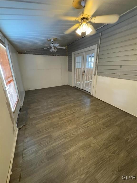 empty room with ceiling fan, french doors, and dark hardwood / wood-style flooring