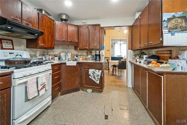 kitchen featuring sink, white gas stove, and tasteful backsplash