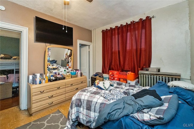 bedroom featuring ceiling fan, a textured ceiling, and hardwood / wood-style flooring