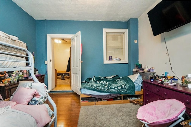 bedroom with hardwood / wood-style floors and a textured ceiling