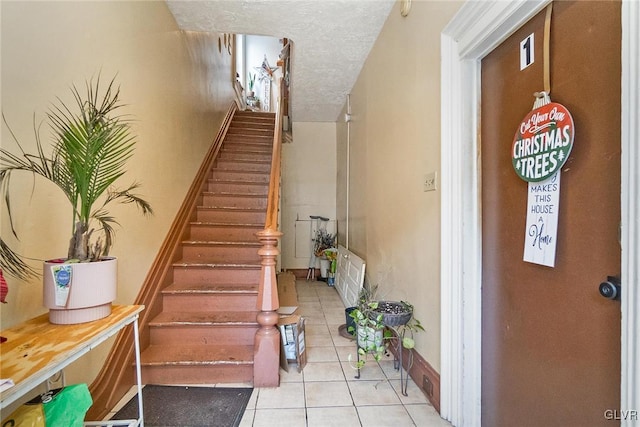 stairs featuring a textured ceiling and tile patterned flooring