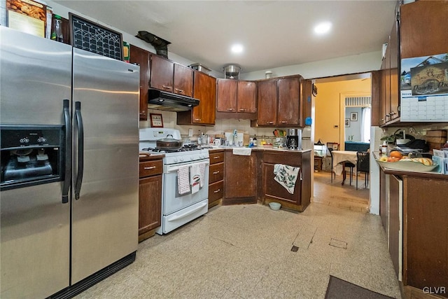 kitchen with white range with gas cooktop, stainless steel refrigerator with ice dispenser, and tasteful backsplash