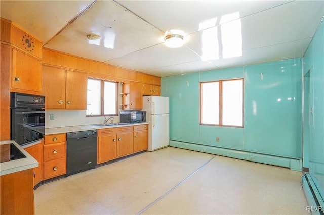 kitchen featuring sink, a baseboard heating unit, and black appliances