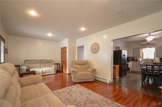 living room featuring a wall mounted air conditioner, a baseboard radiator, sink, ceiling fan, and dark hardwood / wood-style floors