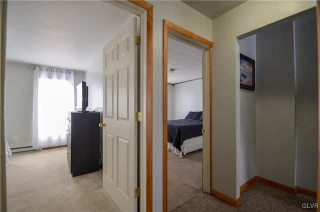 corridor featuring light carpet and a baseboard heating unit