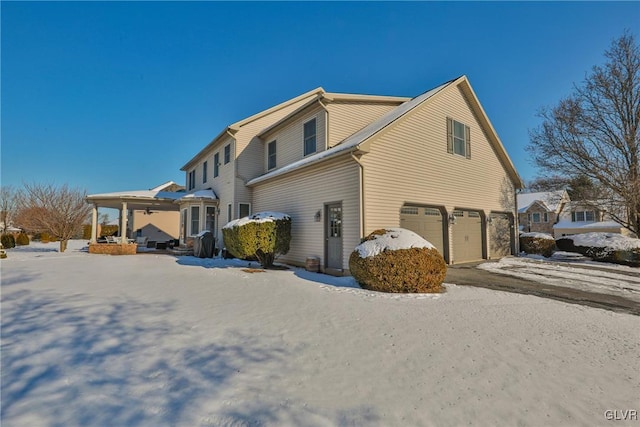 snow covered property featuring a garage