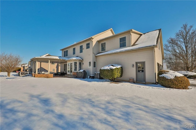 snow covered rear of property with central AC