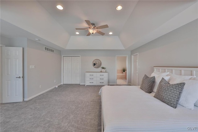 bedroom with a closet, ceiling fan, carpet, and a raised ceiling