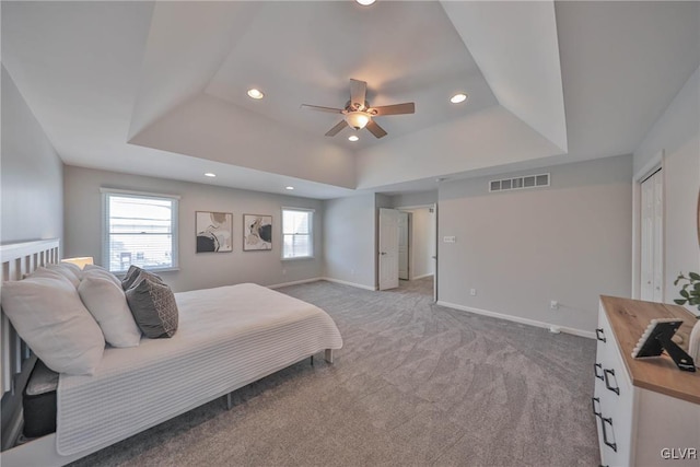 bedroom with ceiling fan, a closet, a raised ceiling, and carpet flooring