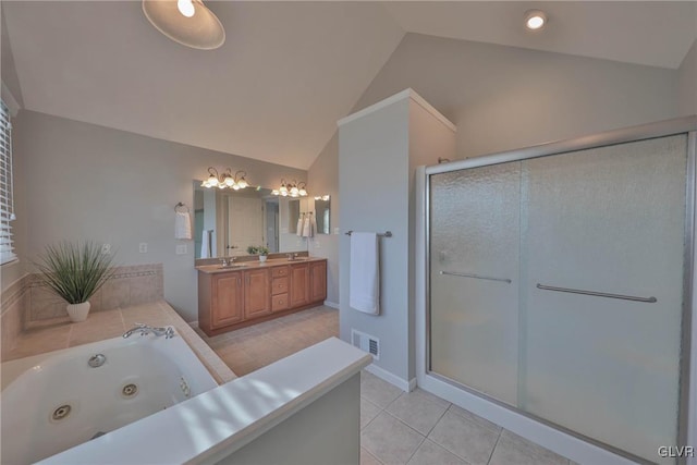 bathroom featuring vanity, vaulted ceiling, shower with separate bathtub, and tile patterned floors