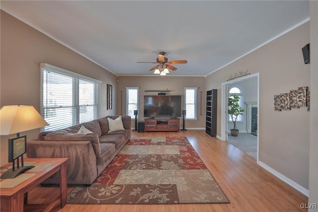 living room with ceiling fan, ornamental molding, and wood-type flooring