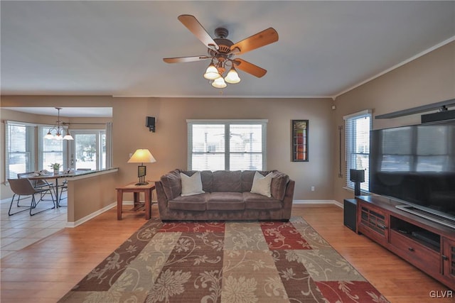 living room with ceiling fan, a wealth of natural light, and light wood-type flooring