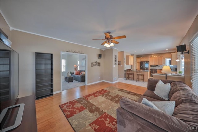 living room featuring ceiling fan, light hardwood / wood-style flooring, and ornamental molding