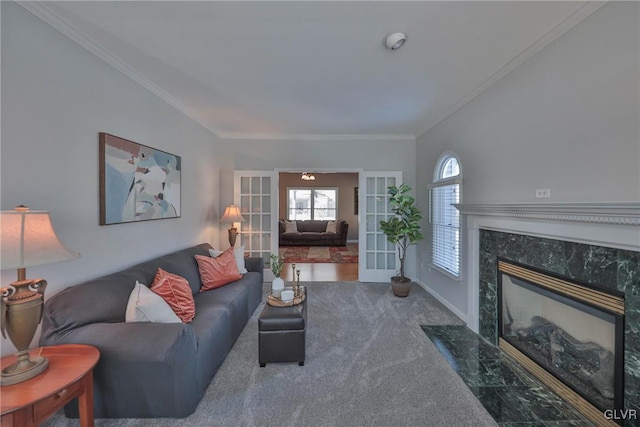 living room with dark carpet, a high end fireplace, ornamental molding, and french doors