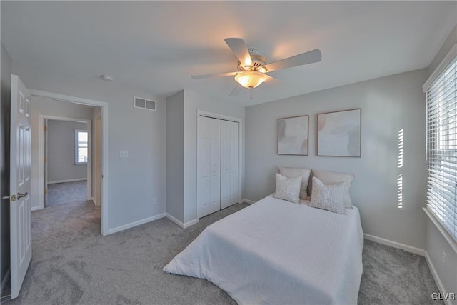 bedroom with ceiling fan, a closet, and light carpet