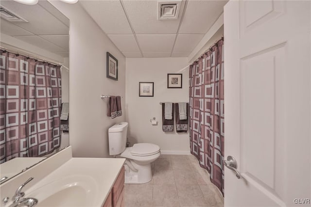 bathroom featuring vanity, toilet, a paneled ceiling, and tile patterned flooring