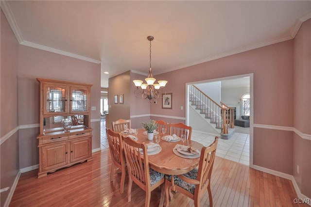 dining room featuring light wood-type flooring, a chandelier, and ornamental molding