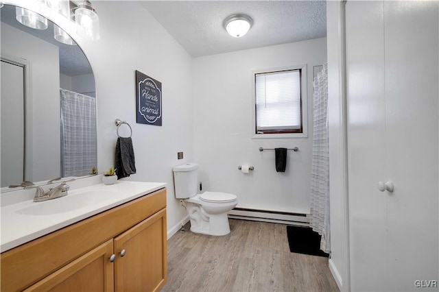 bathroom with hardwood / wood-style flooring, baseboard heating, a textured ceiling, and toilet