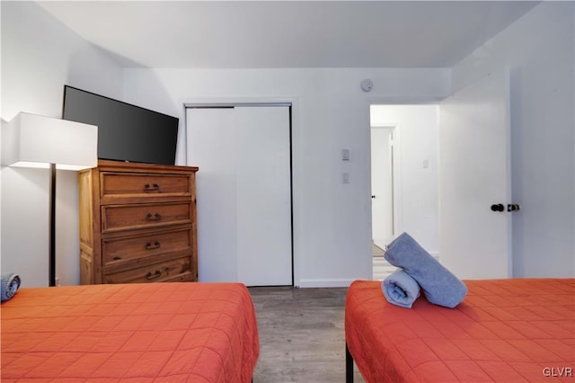 bedroom with hardwood / wood-style floors and a closet