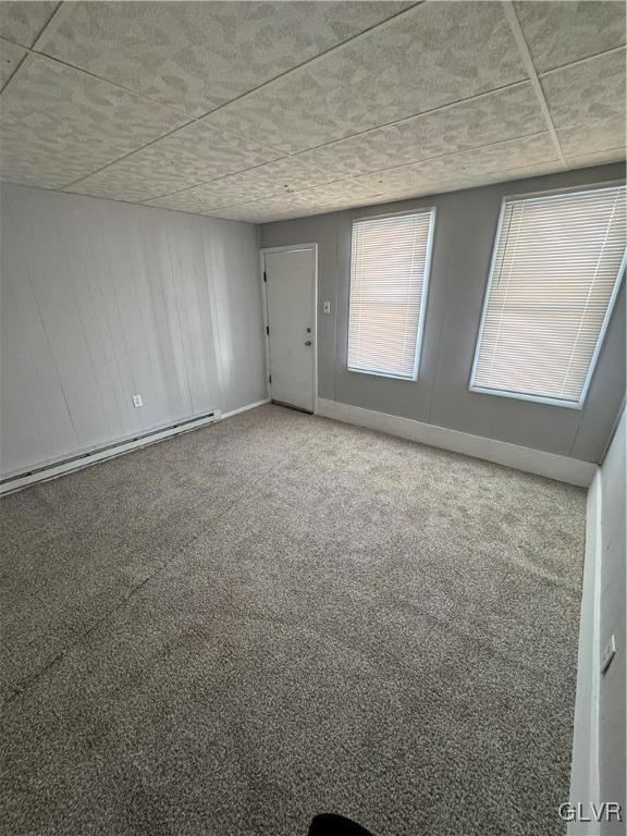 carpeted spare room featuring a baseboard radiator