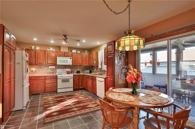 kitchen with ceiling fan, white appliances, tasteful backsplash, and hanging light fixtures