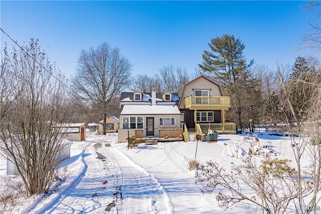 snow covered back of property with a balcony