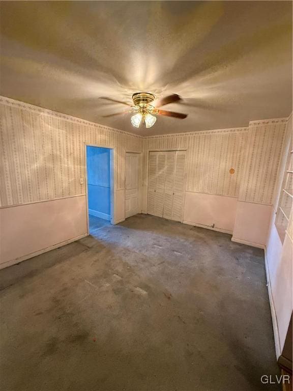 spare room with dark carpet and ceiling fan