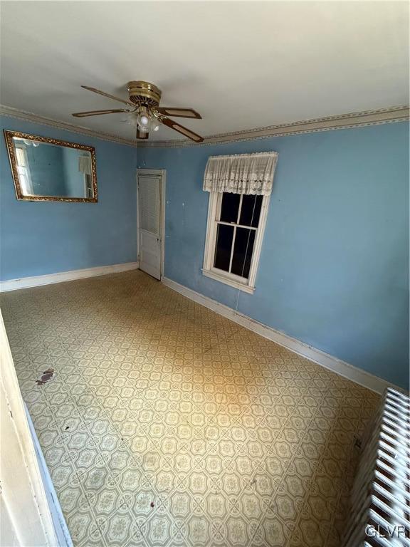 unfurnished room with ornamental molding and ceiling fan