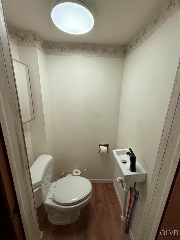 bathroom featuring hardwood / wood-style flooring and toilet