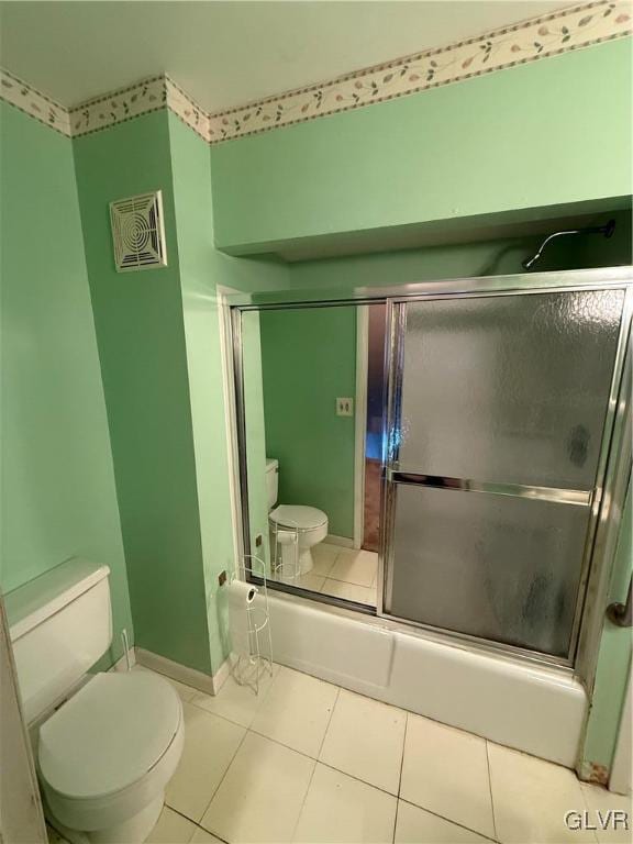 bathroom with toilet, combined bath / shower with glass door, and tile patterned flooring