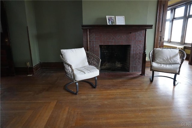 sitting room featuring dark parquet flooring and a fireplace