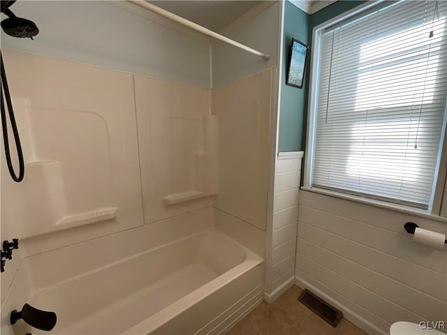 bathroom featuring tile patterned floors, shower / bathing tub combination, and tile walls