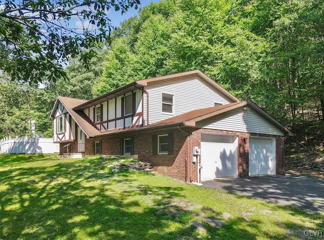 rear view of property featuring a garage and a yard