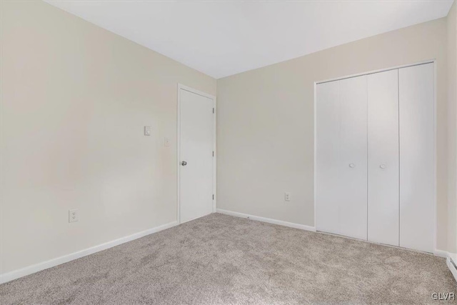 unfurnished bedroom featuring a closet and light carpet