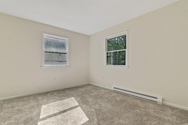 spare room featuring light carpet and a baseboard radiator