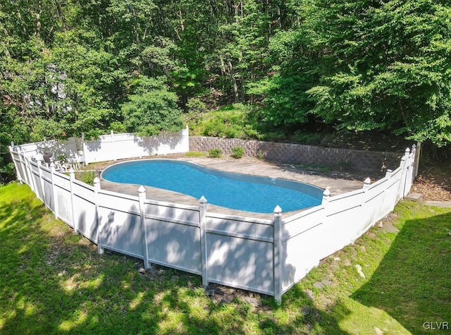 view of pool with a lawn