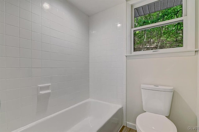 bathroom featuring tiled shower / bath and toilet