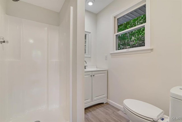 bathroom with vanity, wood-type flooring, a shower, and toilet