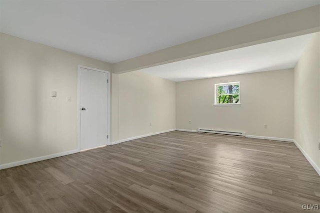 unfurnished room with a baseboard radiator and dark hardwood / wood-style floors