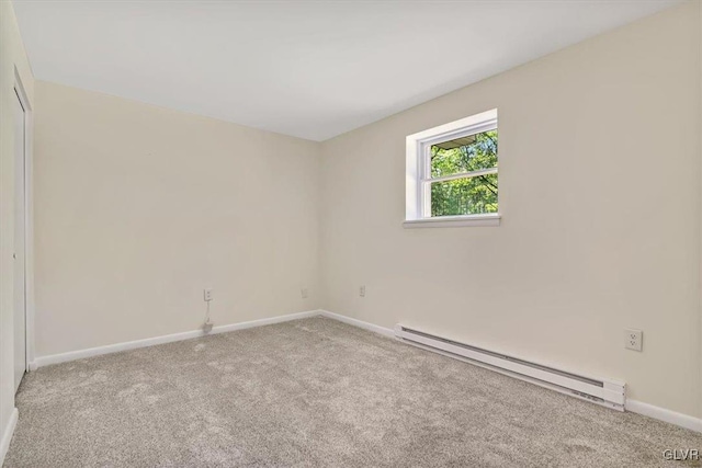 spare room with a baseboard heating unit and light carpet