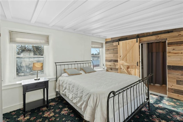 bedroom with multiple windows and a barn door